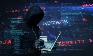Cyberprzestępca w kapturze planuje ataki hakerskie, używając laptopa i karty kredytowej. W tle widać kod i napisy "VIRUS", "ATTACK", "MALWARE", "SECURITY".